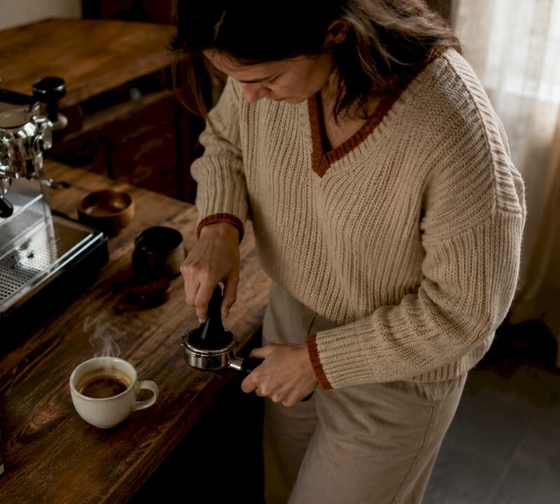 Woman making espresso at home office counter