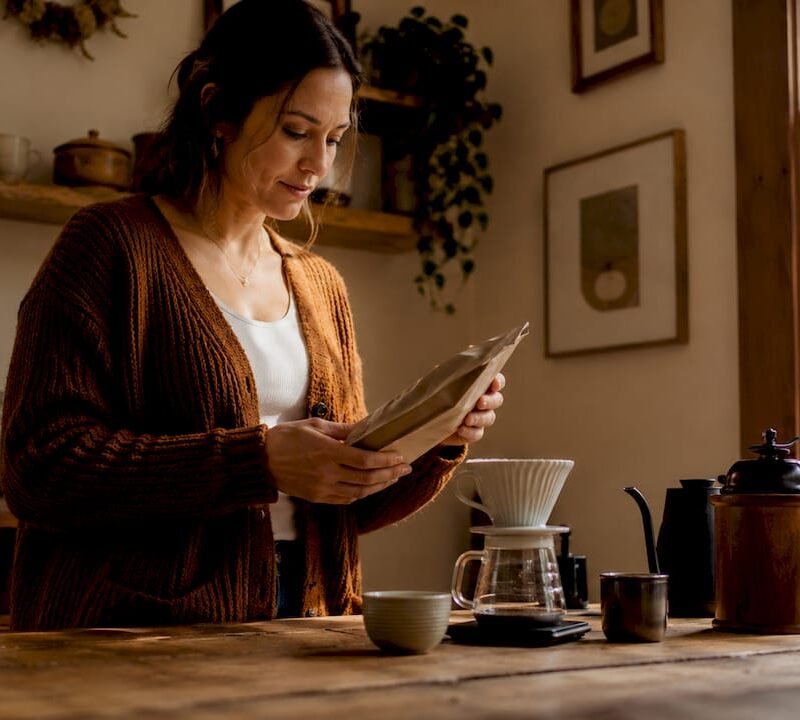 Woman examining small batch roasted coffee bag