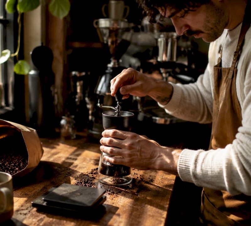 Barista grinding freshly roasted coffee beans