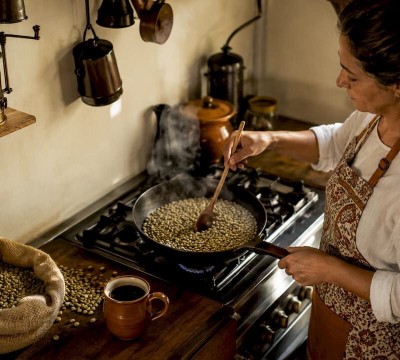 Woman roasting coffee beans on stovetop